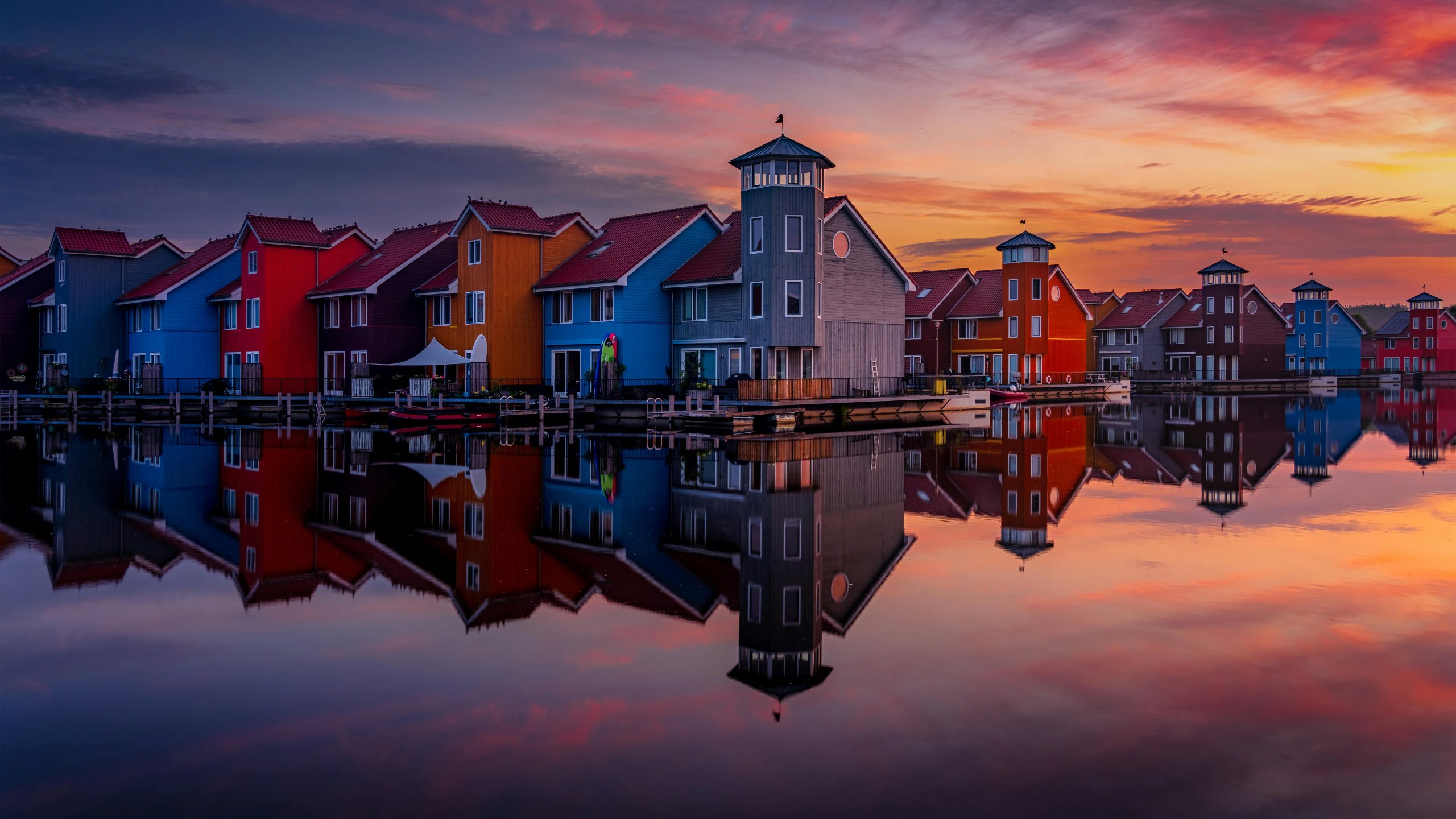 Kleurrijke woningen aan het water bij zonsondergang